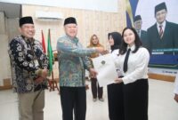 Plt. Kepala Kanwil Kemenag Lampung, Erwinto, secara simbolis menyerahkan SK kepada para CPNS. Foto: Humas Kemenag Lampung
